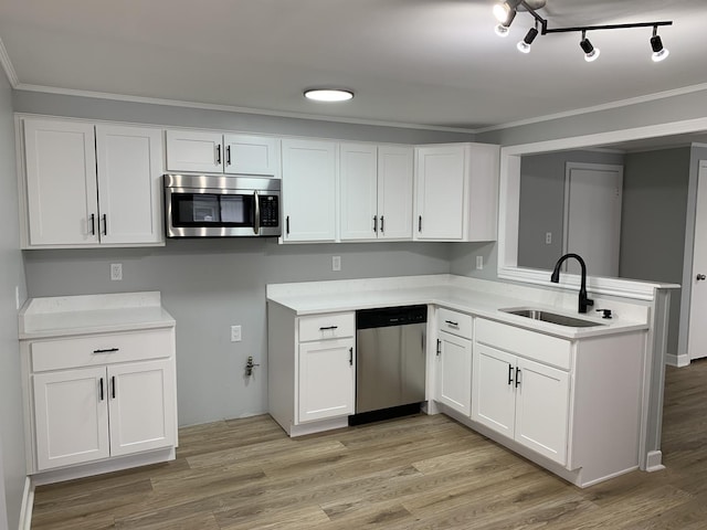 kitchen with kitchen peninsula, appliances with stainless steel finishes, light wood-type flooring, sink, and white cabinets