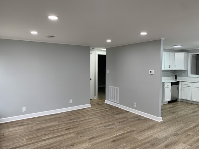 unfurnished living room with light wood-type flooring and ornamental molding