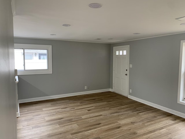 foyer featuring light hardwood / wood-style floors and crown molding