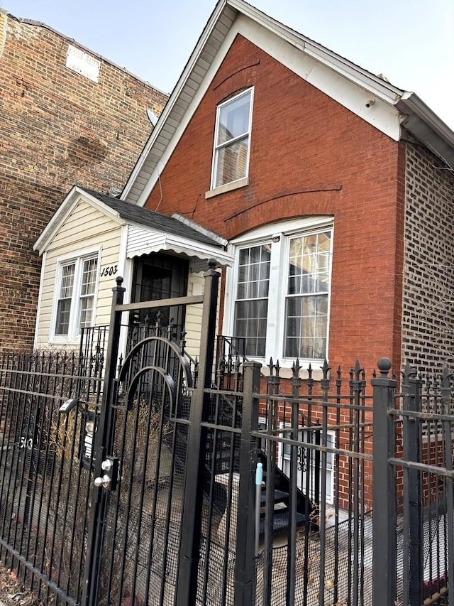 view of front of house featuring a gate, brick siding, and a fenced front yard