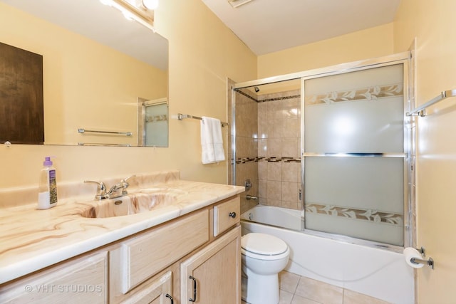 full bathroom featuring toilet, vanity, tile patterned floors, and enclosed tub / shower combo