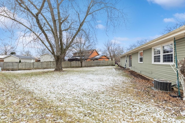 yard layered in snow featuring central air condition unit