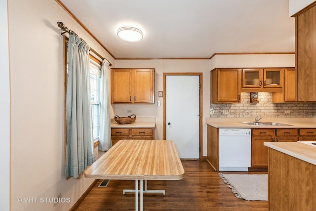 kitchen featuring dishwasher, sink, dark hardwood / wood-style flooring, decorative backsplash, and ornamental molding