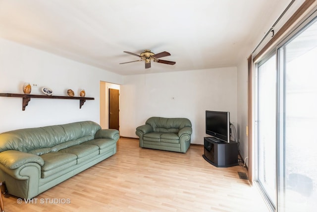 living room featuring ceiling fan and light hardwood / wood-style flooring