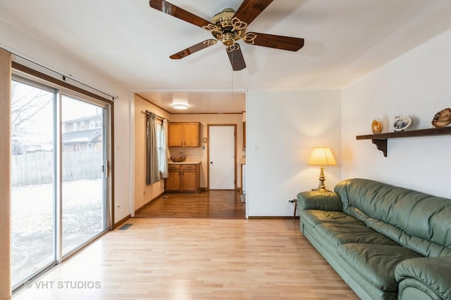 living room featuring ceiling fan and light hardwood / wood-style floors