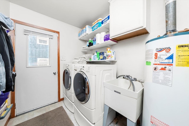 washroom with cabinets, washer and clothes dryer, gas water heater, and sink