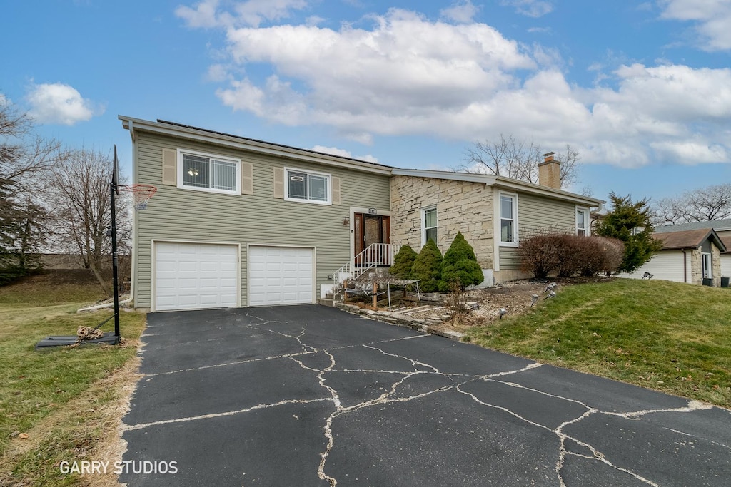 bi-level home featuring a front yard and a garage