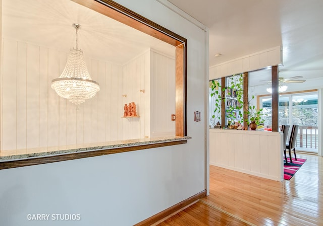 interior space with light wood-type flooring, ornamental molding, and an inviting chandelier