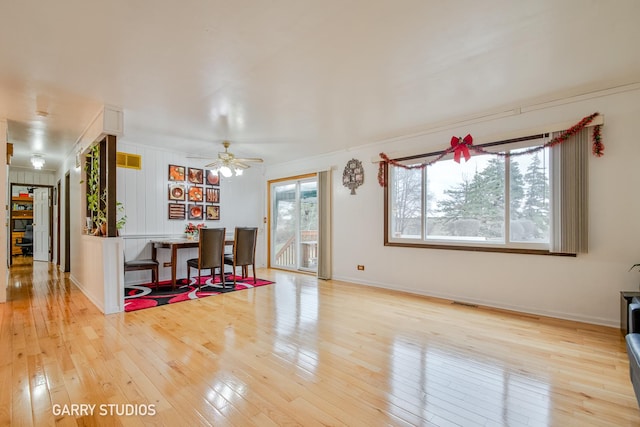 dining room with light wood-type flooring, ceiling fan, and ornamental molding