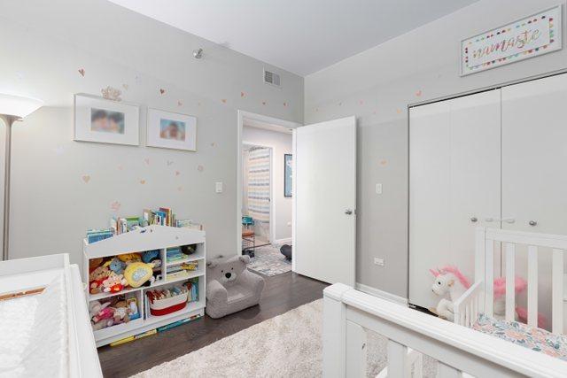 bedroom featuring a closet, a nursery area, and dark hardwood / wood-style floors