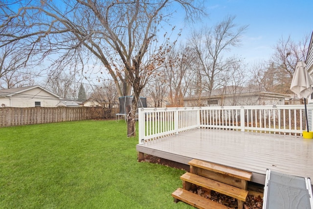 view of yard featuring a wooden deck and a trampoline