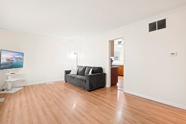 living room featuring ornamental molding and light wood-type flooring