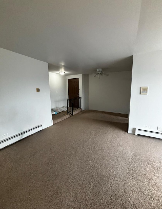 empty room featuring a baseboard heating unit, ceiling fan, and carpet