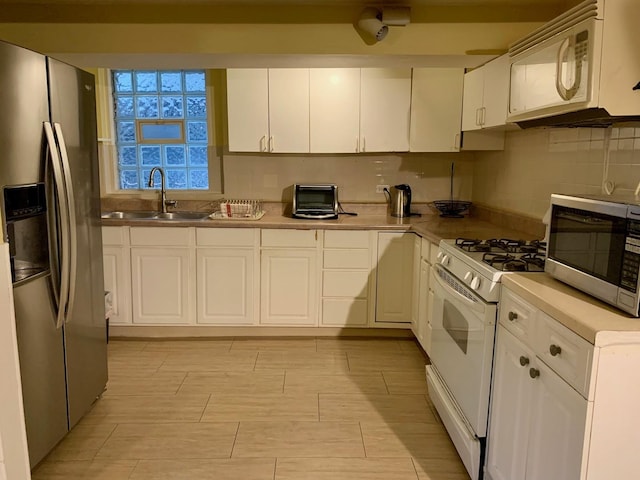 kitchen with sink, white cabinets, and stainless steel appliances