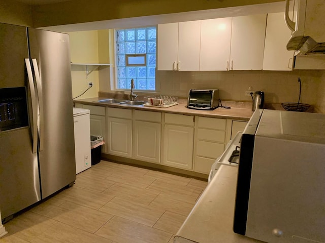 kitchen with sink, tasteful backsplash, stainless steel fridge with ice dispenser, white cabinets, and white stove