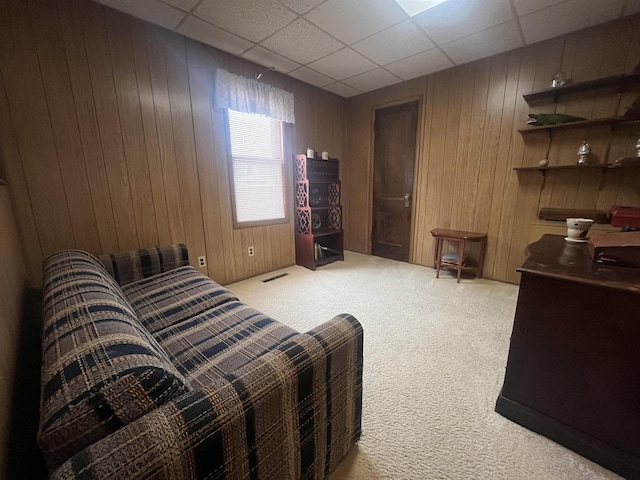 bedroom with wood walls and light colored carpet