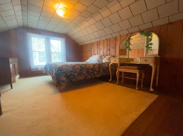 carpeted bedroom featuring wood walls and lofted ceiling