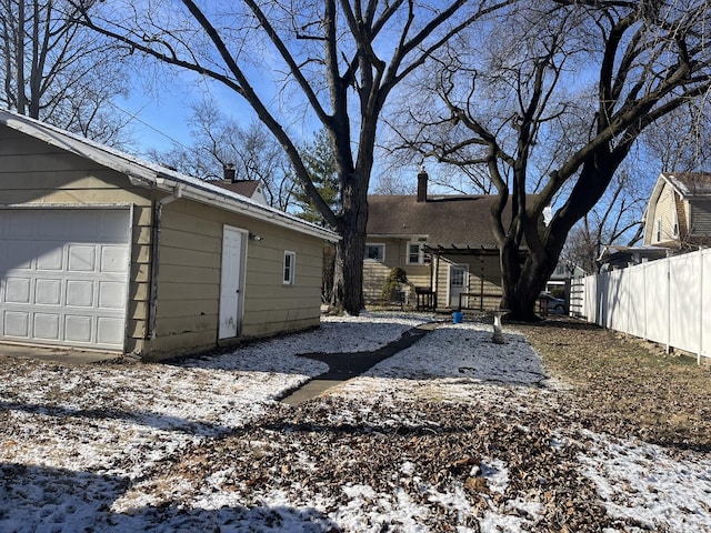 snow covered property with a garage