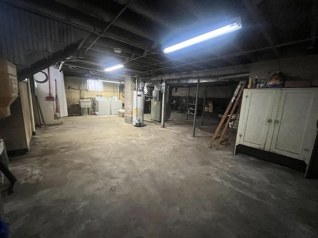 basement with heating unit, sink, gas water heater, and independent washer and dryer