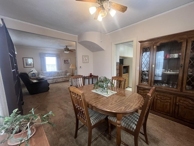 dining space with ceiling fan, carpet, and ornamental molding