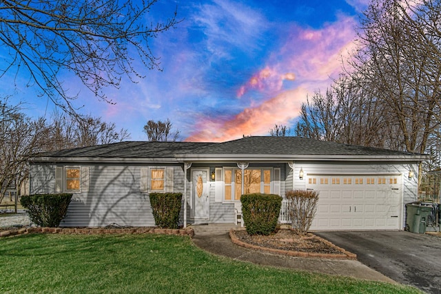 ranch-style house featuring a garage and a yard