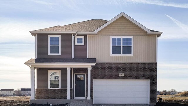 front of property with a garage and a yard