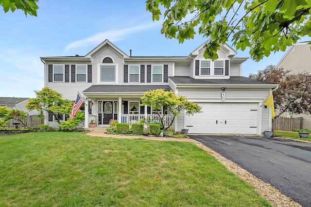 view of front of house featuring a porch, a front yard, and a garage