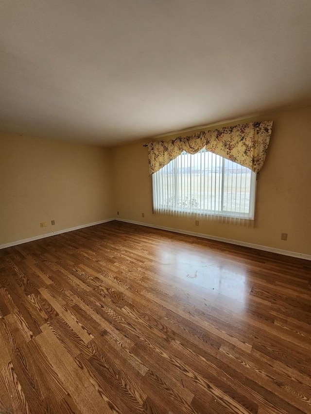 unfurnished room with dark wood-type flooring