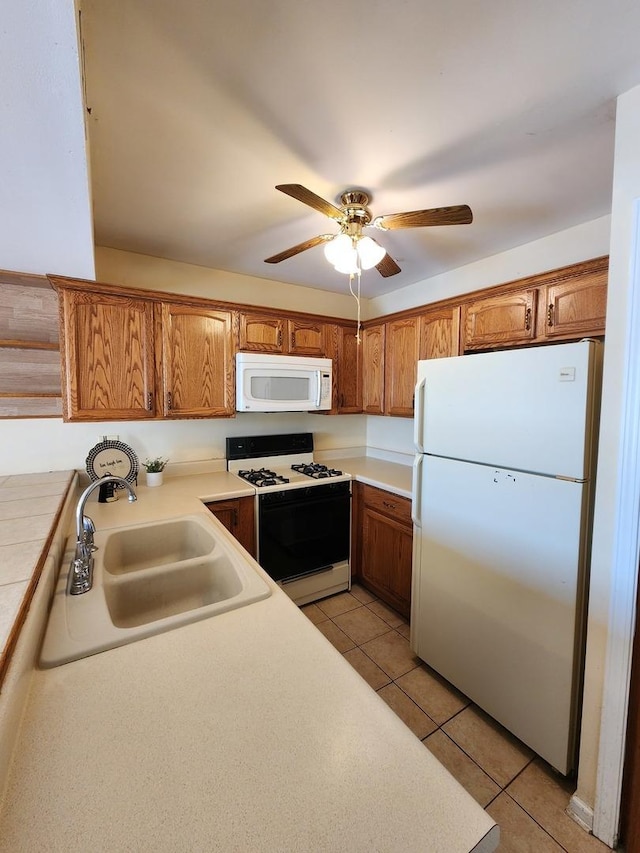 kitchen with ceiling fan, sink, light tile patterned floors, and white appliances