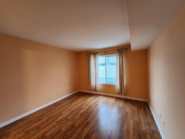 spare room featuring dark wood-type flooring