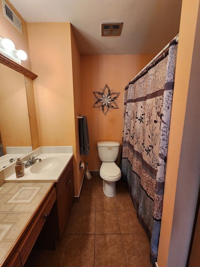 bathroom with tile patterned flooring, vanity, and toilet