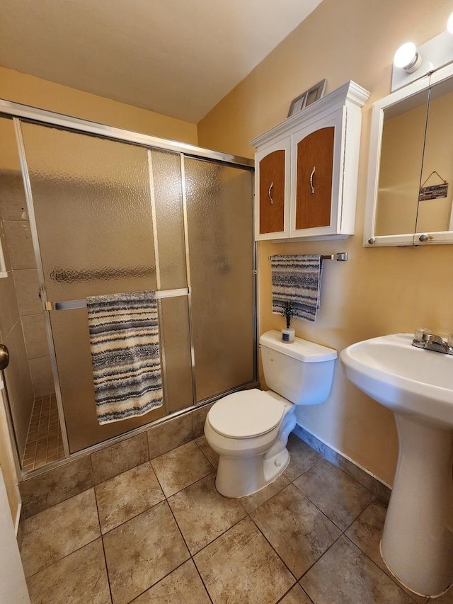 bathroom featuring toilet, an enclosed shower, and sink