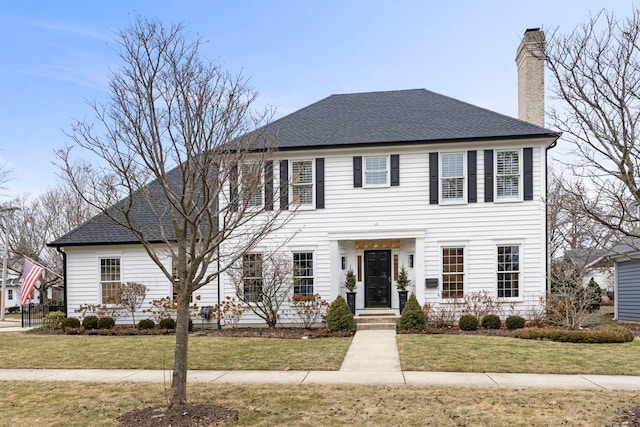 colonial house featuring a front lawn