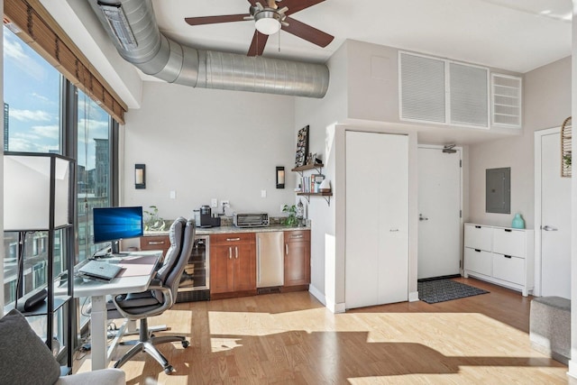 office space with electric panel, ceiling fan, wine cooler, and light wood-type flooring