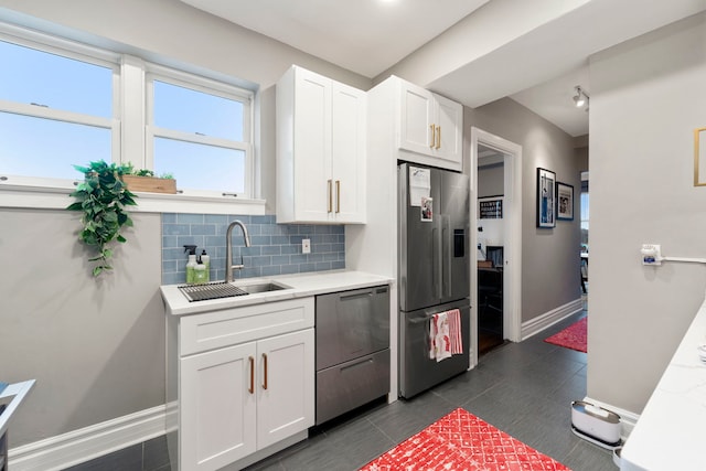 kitchen with sink, white cabinetry, stainless steel appliances, and tasteful backsplash