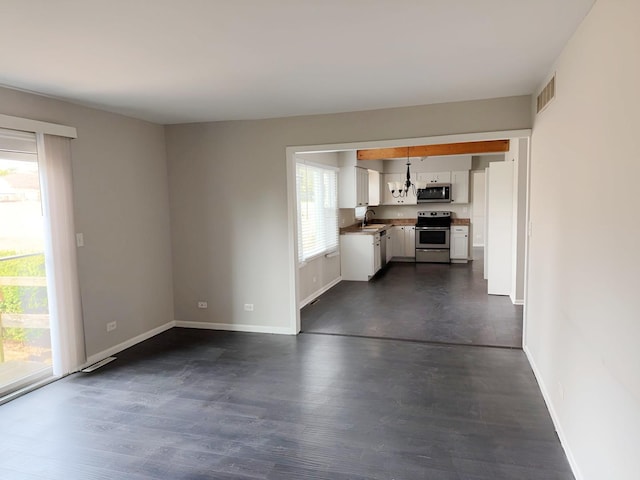 6111 Pingree Rd, Crystal Lake, IL 60014 - unfurnished living room featuring a sink, baseboards, and dark wood-type flooring