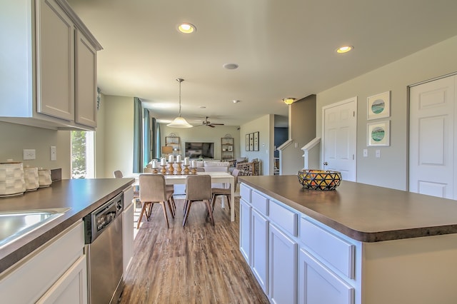 kitchen with a center island, stainless steel dishwasher, ceiling fan, decorative light fixtures, and wood-type flooring