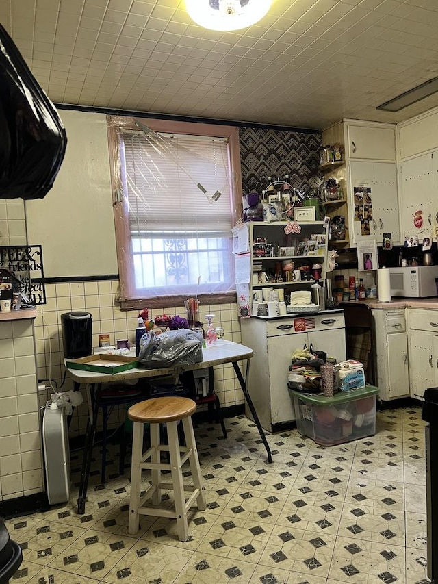 kitchen with white cabinetry and tile walls