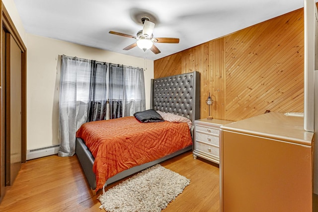 16734 Evans Ave, South Holland, IL 60473 - bedroom with a baseboard heating unit, light wood finished floors, wood walls, a ceiling fan, and a closet