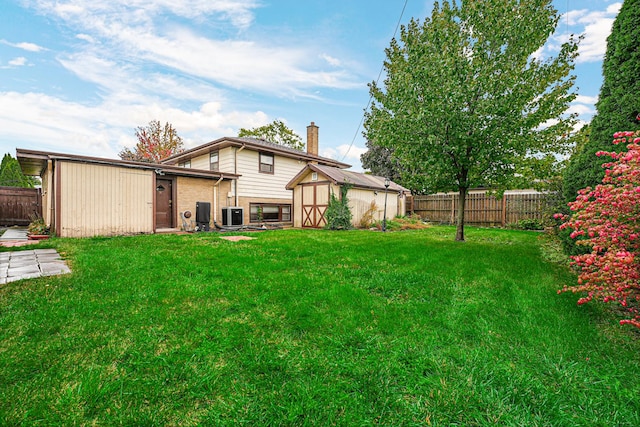 16734 Evans Ave, South Holland, IL 60473 - back of house with a fenced backyard, a shed, brick siding, and a chimney