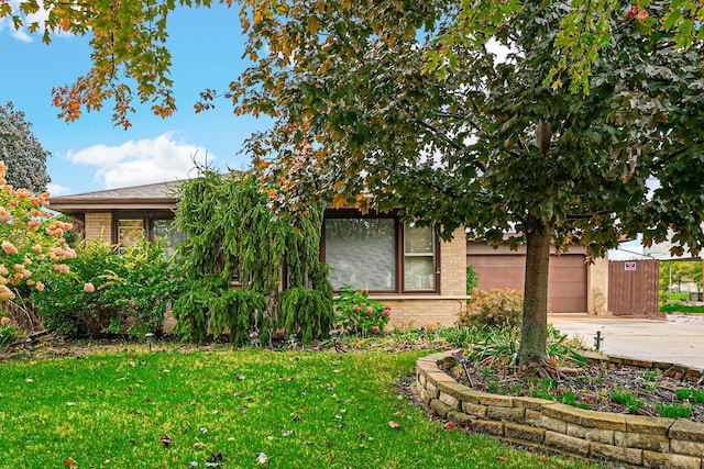 obstructed view of property featuring a front yard and a garage