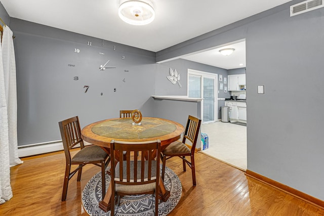 16734 Evans Ave, South Holland, IL 60473 - dining room featuring a baseboard heating unit and light wood-style flooring
