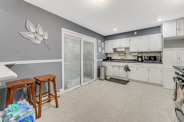16734 Evans Ave, South Holland, IL 60473 - kitchen featuring dark countertops, white cabinets, stainless steel microwave, recessed lighting, and range