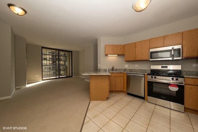 kitchen featuring kitchen peninsula, sink, light colored carpet, and stainless steel appliances