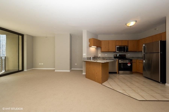 kitchen featuring kitchen peninsula, appliances with stainless steel finishes, light carpet, and sink