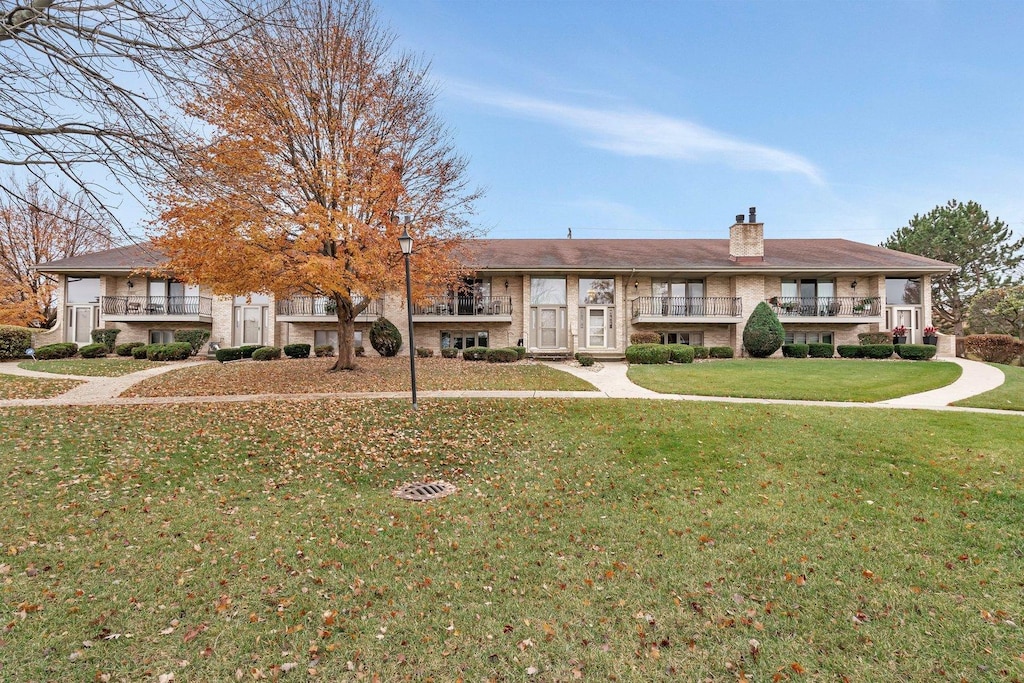 view of front of property with a balcony and a front yard