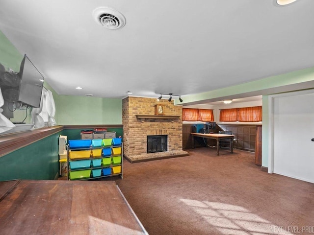 playroom featuring a fireplace, carpet, and track lighting