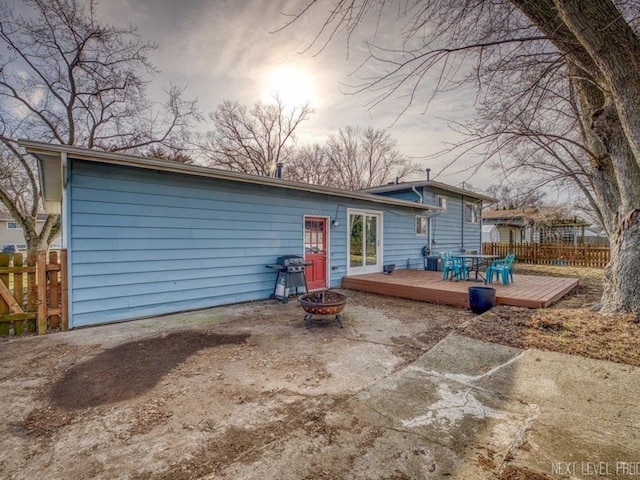 back of house with an outdoor fire pit and a wooden deck