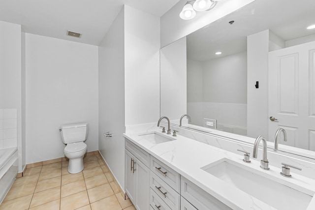 bathroom featuring tile patterned flooring, vanity, toilet, and a bathing tub