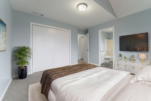 bedroom with carpet flooring, vaulted ceiling, ensuite bath, and a closet